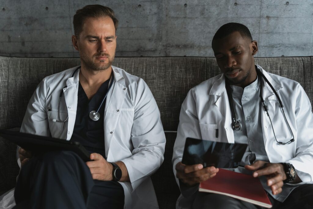 Two doctors analyze X-ray films in a medical office for diagnosis.