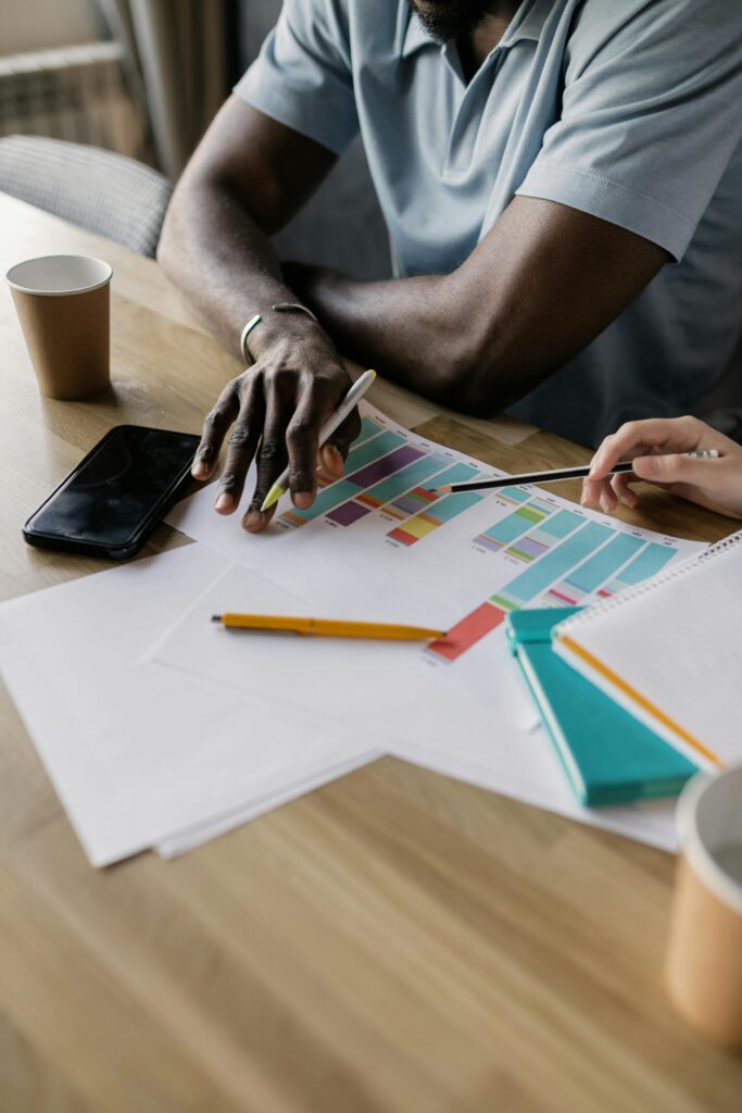 Two business professionals collaborating on a colorful project plan indoors.